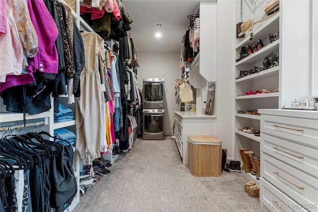 walk in closet with light carpet