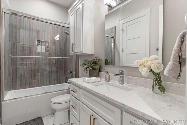 full bath featuring combined bath / shower with glass door, vanity, and toilet