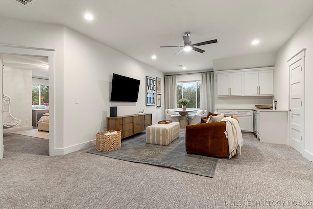 living room featuring recessed lighting, baseboards, a ceiling fan, and light colored carpet