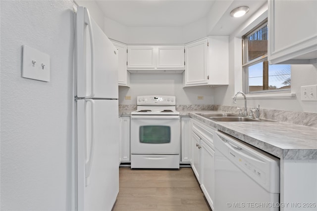 kitchen featuring light wood finished floors, white appliances, white cabinetry, and a sink