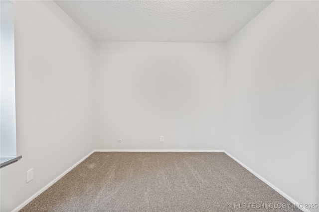carpeted empty room featuring baseboards and a textured ceiling