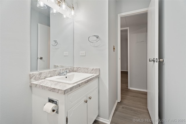 bathroom featuring vanity, baseboards, and wood finished floors