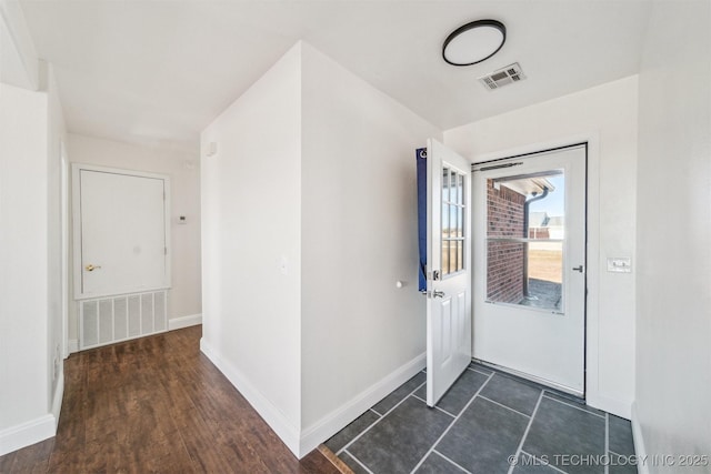 foyer featuring baseboards and visible vents