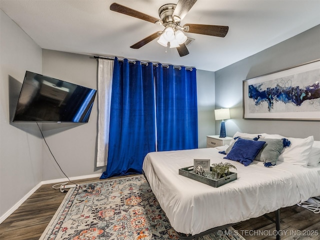 bedroom featuring ceiling fan, wood finished floors, and baseboards