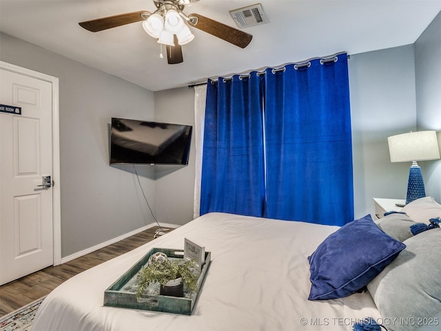 bedroom featuring visible vents, ceiling fan, baseboards, and wood finished floors