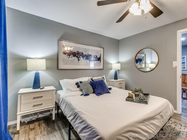 bedroom with ceiling fan, wood finished floors, and baseboards