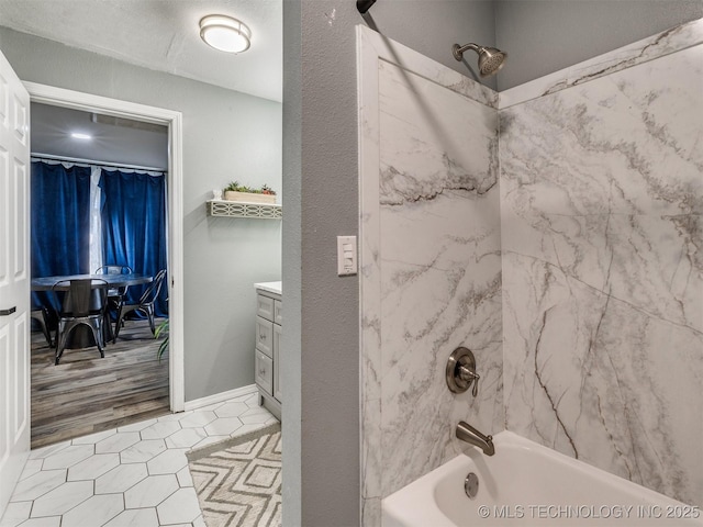 bathroom featuring shower / washtub combination, vanity, and baseboards