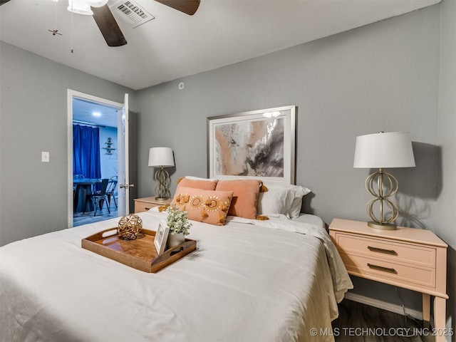 bedroom featuring ceiling fan, wood finished floors, and visible vents