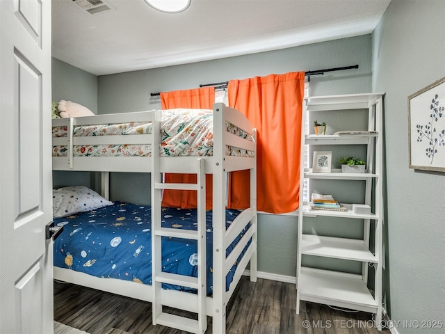 bedroom featuring wood finished floors and visible vents