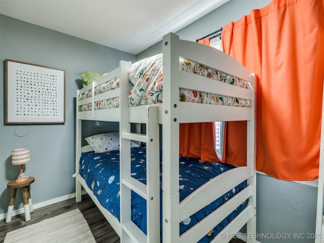 bedroom featuring baseboards and wood finished floors