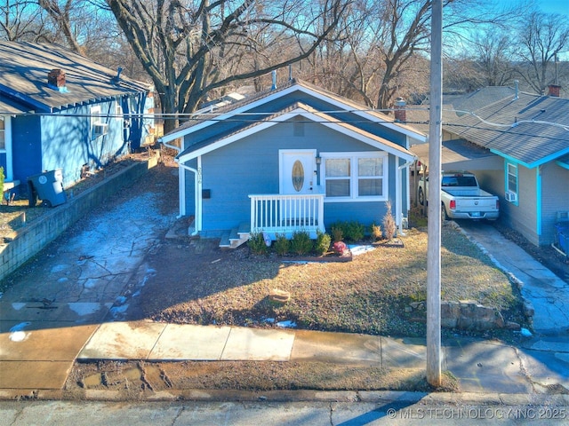 view of front of home featuring driveway, a porch, and a carport