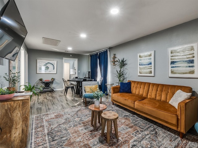 living area with wood finished floors, visible vents, and recessed lighting