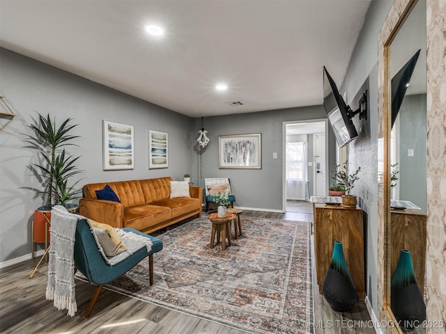 living area with recessed lighting, wood finished floors, visible vents, and baseboards