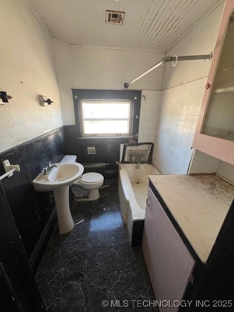 full bathroom with visible vents, toilet, a wainscoted wall, wood ceiling, and tile walls