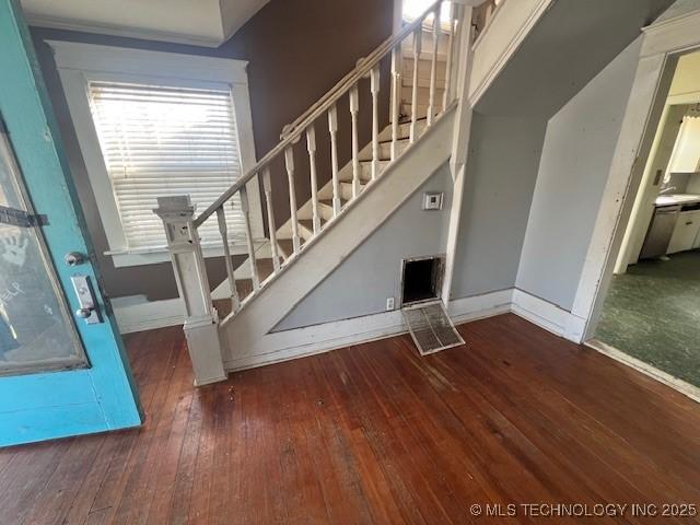 staircase featuring baseboards and hardwood / wood-style floors