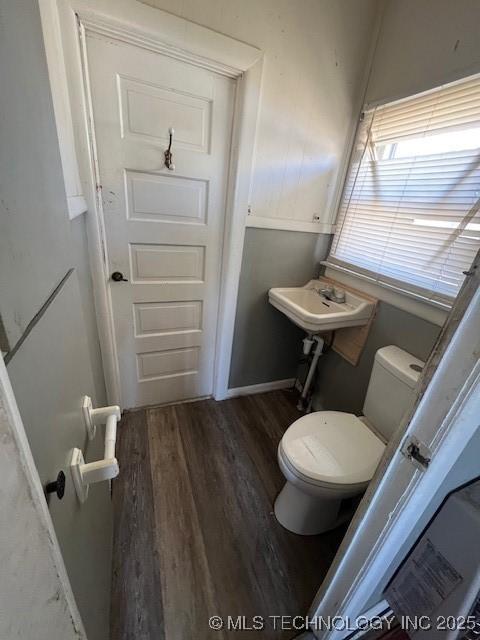 bathroom with a sink, wood finished floors, and toilet