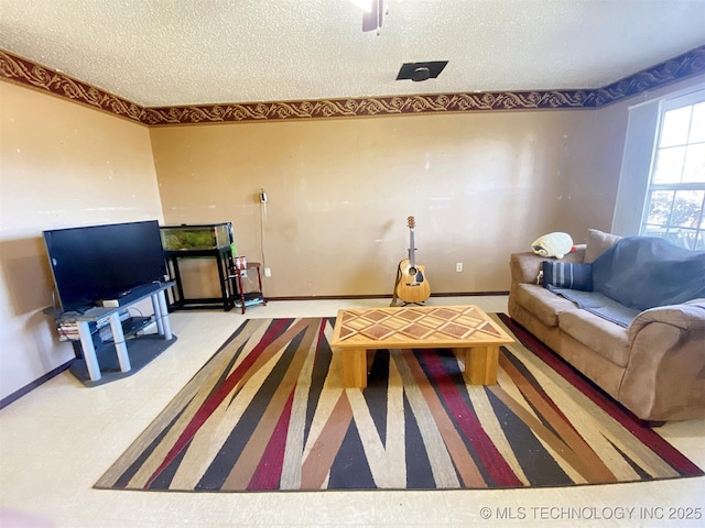 living room featuring a textured ceiling and baseboards