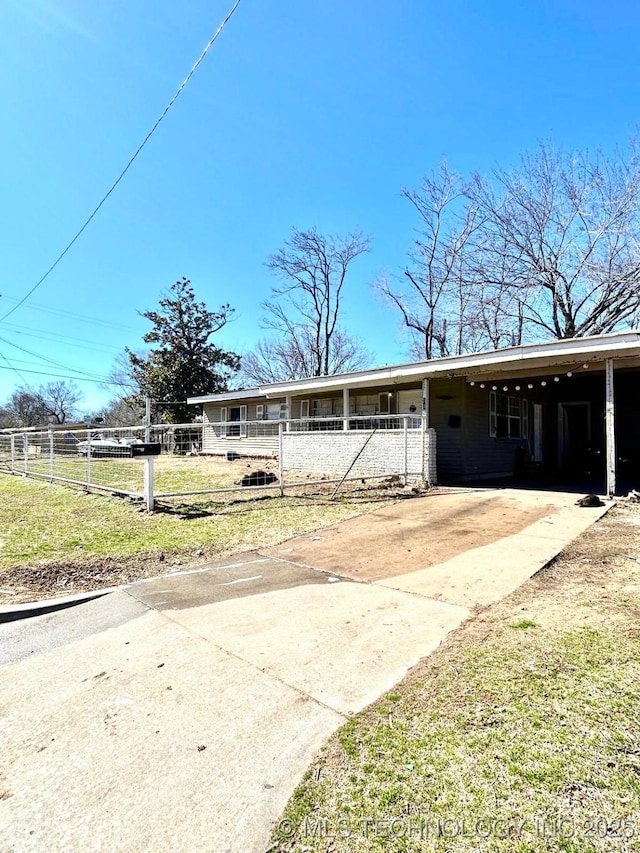 view of front of property with a carport, driveway, and fence