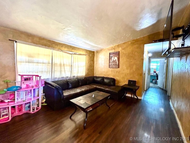 living area featuring vaulted ceiling and wood finished floors