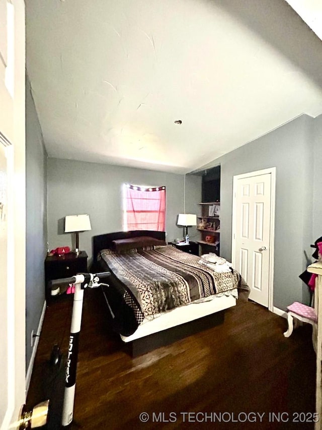 bedroom with baseboards and wood finished floors