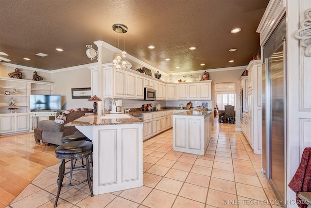 kitchen featuring a textured ceiling, light tile patterned floors, a peninsula, a breakfast bar, and stainless steel microwave