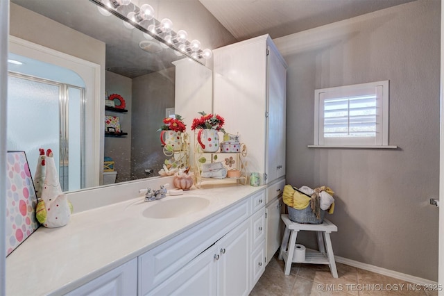 bathroom with vanity, baseboards, and tile patterned floors