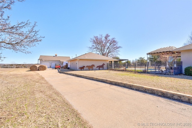 view of front facade with a garage, driveway, a front lawn, and fence