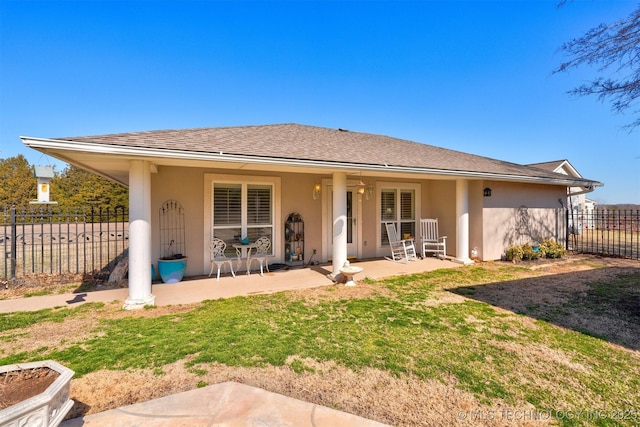 back of property with a patio area, a shingled roof, fence, and stucco siding