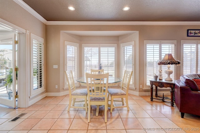 dining area with light tile patterned floors, ornamental molding, a textured ceiling, and visible vents