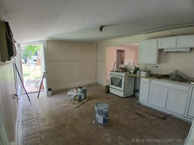 kitchen with white range with gas stovetop, baseboards, white cabinets, and light countertops