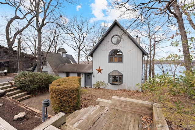 view of front facade with a water view and a chimney