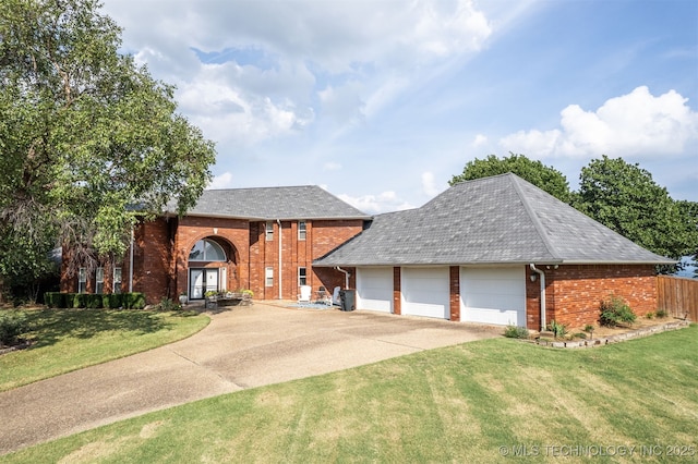 view of front facade featuring a garage, driveway, a front lawn, and brick siding