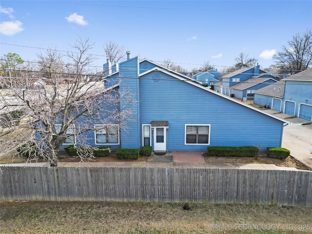 view of side of property with a fenced front yard and a chimney