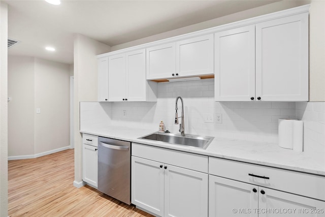 kitchen with visible vents, white cabinets, light wood-type flooring, stainless steel dishwasher, and a sink