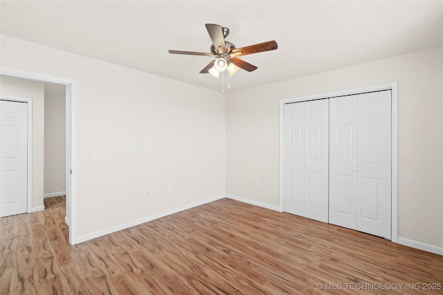 unfurnished bedroom with ceiling fan, light wood finished floors, a closet, and baseboards