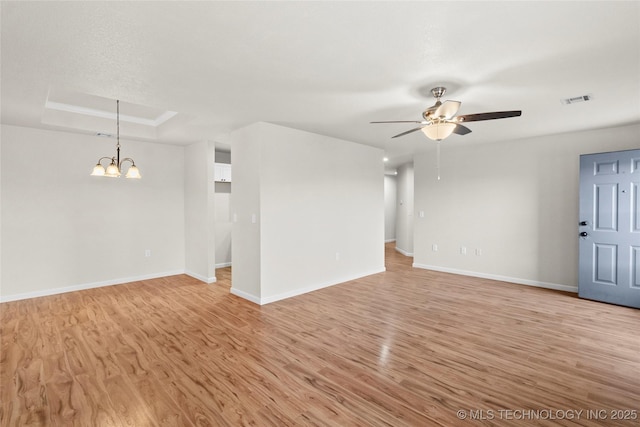 unfurnished living room with baseboards, a raised ceiling, visible vents, and light wood-style floors