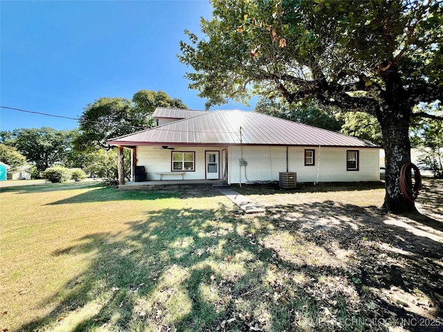 view of front of property with a porch, metal roof, central AC, and a front yard