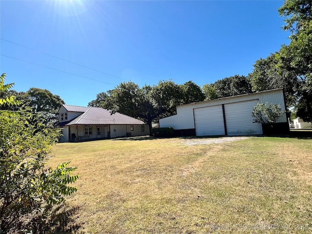 view of yard featuring a garage and an outbuilding