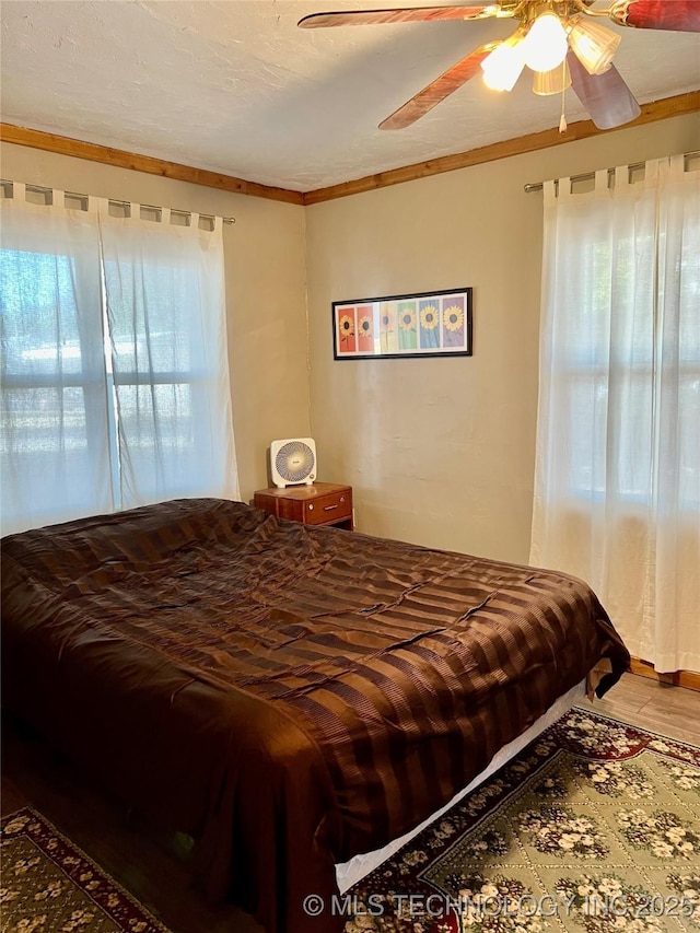 bedroom featuring a textured ceiling, wood finished floors, and a ceiling fan