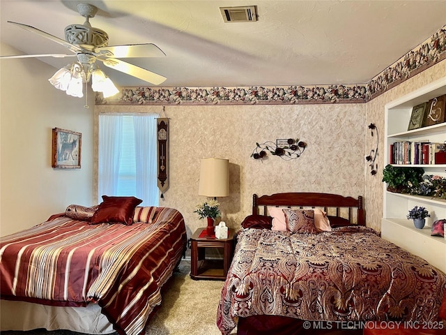 bedroom with ceiling fan, visible vents, and carpet flooring