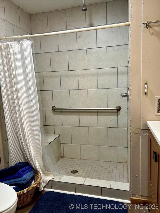 full bathroom featuring toilet, a shower stall, and vanity