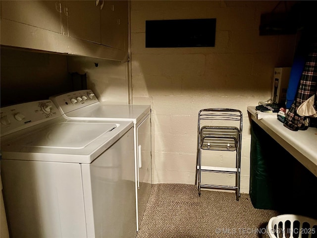 washroom featuring concrete block wall, cabinet space, and washer and dryer