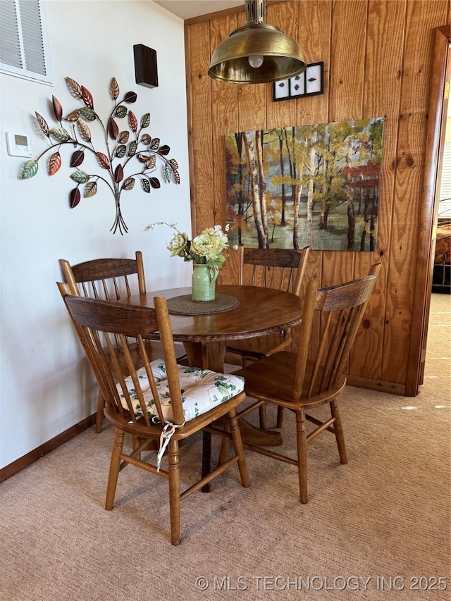 dining area featuring baseboards, visible vents, and light colored carpet