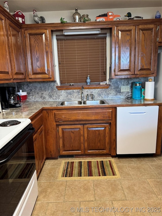 kitchen with brown cabinets, a sink, white dishwasher, backsplash, and range with electric stovetop