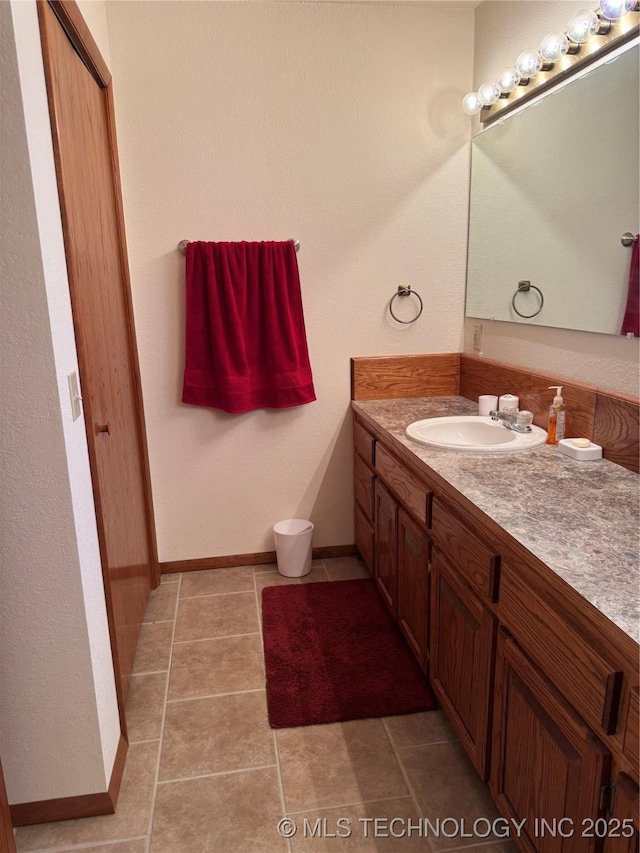 bathroom featuring baseboards, vanity, and tile patterned floors