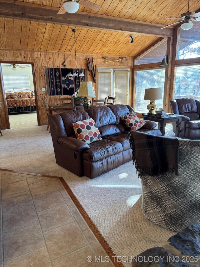 carpeted living room with wooden ceiling, wood walls, ceiling fan, and lofted ceiling with beams