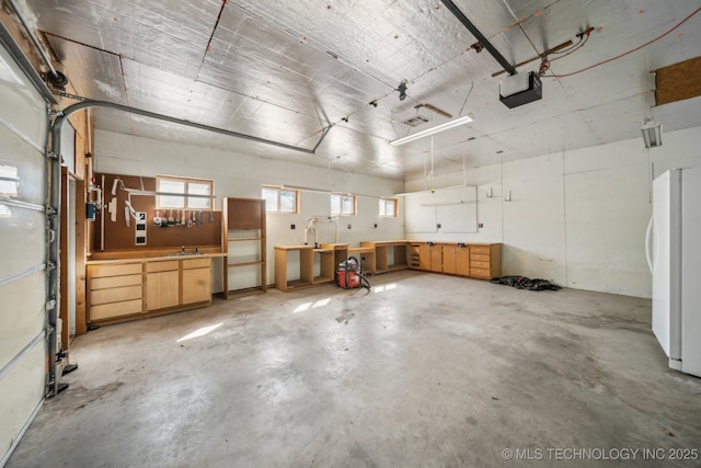 garage featuring a garage door opener and freestanding refrigerator