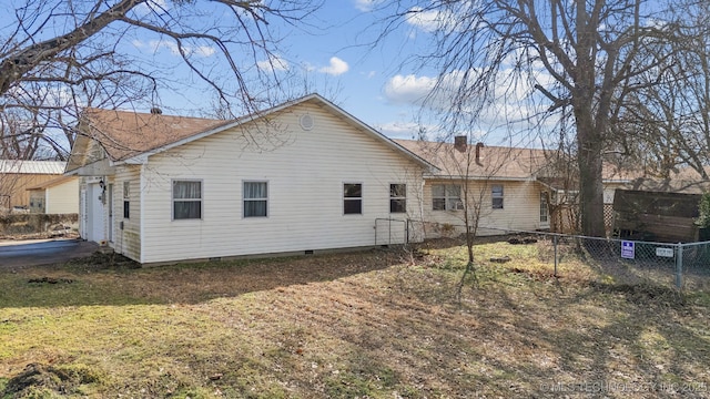 rear view of property featuring crawl space and fence