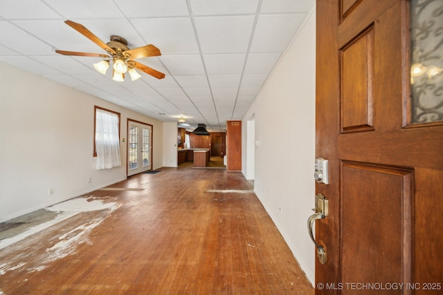 unfurnished living room featuring french doors, hardwood / wood-style flooring, a paneled ceiling, and a ceiling fan