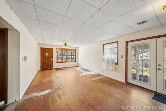 foyer entrance with hardwood / wood-style floors, a drop ceiling, visible vents, and baseboards